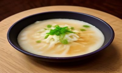 骚麦主编张昊的工作照，他坐在满是书籍和便签的工作桌前认真审阅内容，神情专注，背景是温暖的办公室灯光